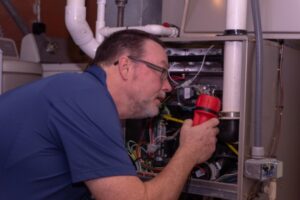professional HVAC technician inspecting a furnace