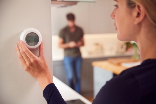 woman adjusting thermostat