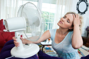 image of a woman dealing with an HVAC emergency and broken AC unit