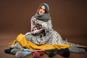 homeowner wrapped in blankets due to uneven heating at home