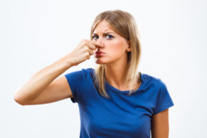 image of a homeowner plugging nose due to a heating oil smell