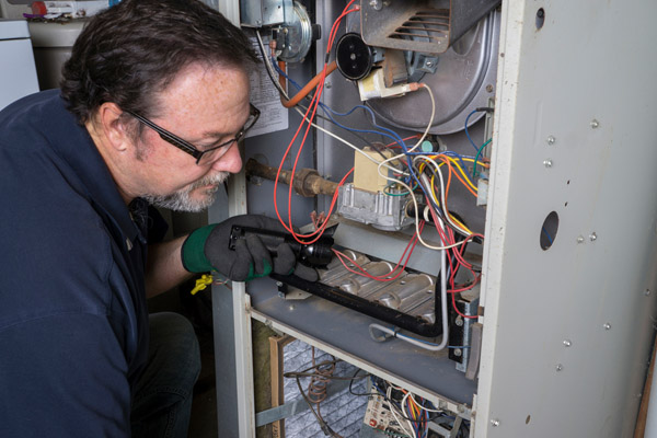 image of an hvac contractor repairing furnace