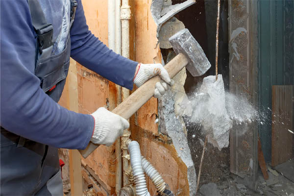 image of construction worker tearing down walls for hvac ductwork