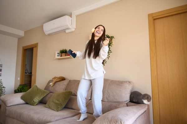 woman dancing on the couch enjoying HVAC Zoning and Airflow Management