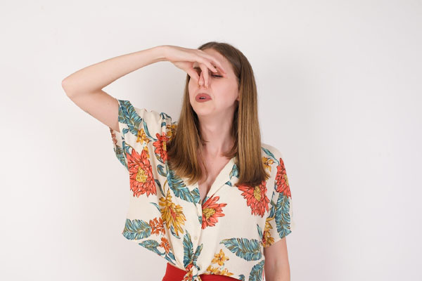 image of a homeowner plugging ears due to air conditioner smells