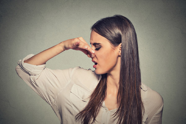 image of homeowner plugging nose due to bad air conditioner smell