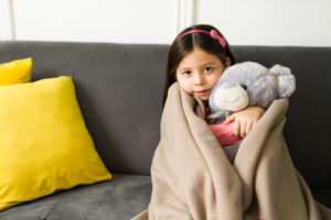 image of a girl feeling chilly due to a home heating emergency and power outage