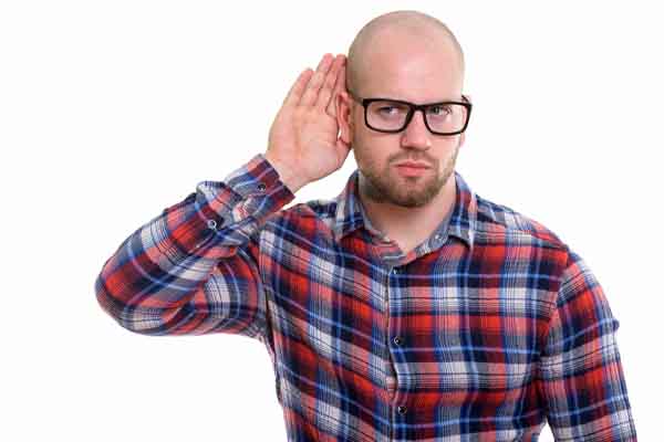 image of a homeowner cupping ear and listening to oil tank alarm