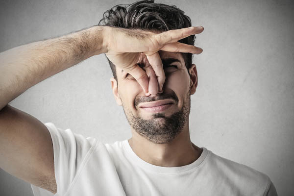 image of a homeowner plugging nose due to a burning furnace odor