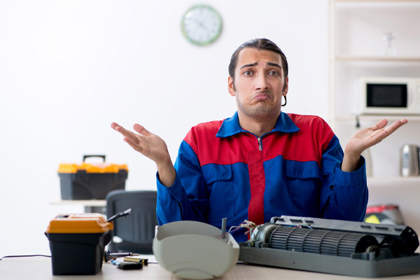 image of confused hvac contractor performing air conditoner repair