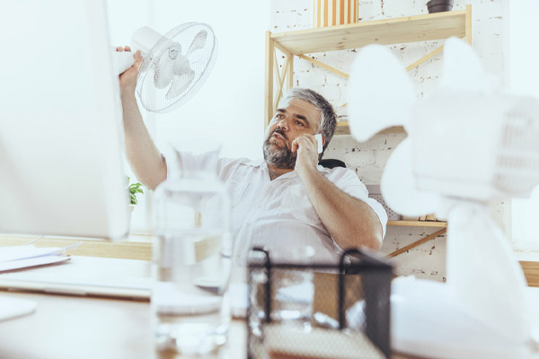 image of homeowner feeling hot due to air conditioner not removing humidity