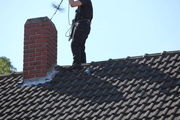 chimney sweep at work on the roof for heater safety