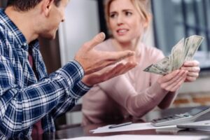 couple discussing while counting money depicting fuel oil price fluctuation