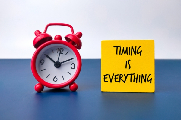 Red alarm clock and colored wooden cube with the phrase timing is everything depicting HVAC air filter replacement