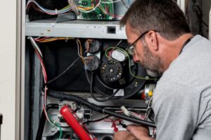 professional HVAC technician performing furnace maintenance